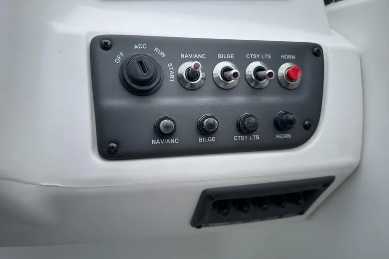 Slide: The Image of Control panel of 2026 Tahoe T18 boat with switches and ignition key. - 25