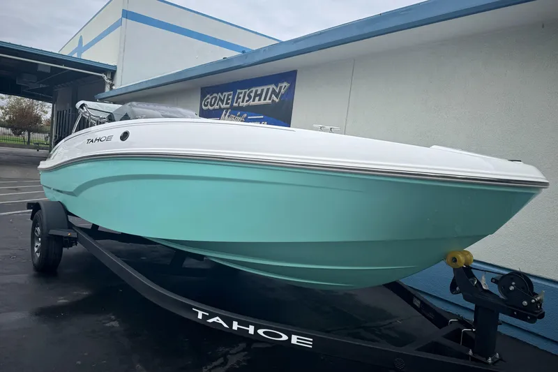 Slide: The Image of 2026 Tahoe T18 boat on trailer, mint green hull, parked outside a building. - 3