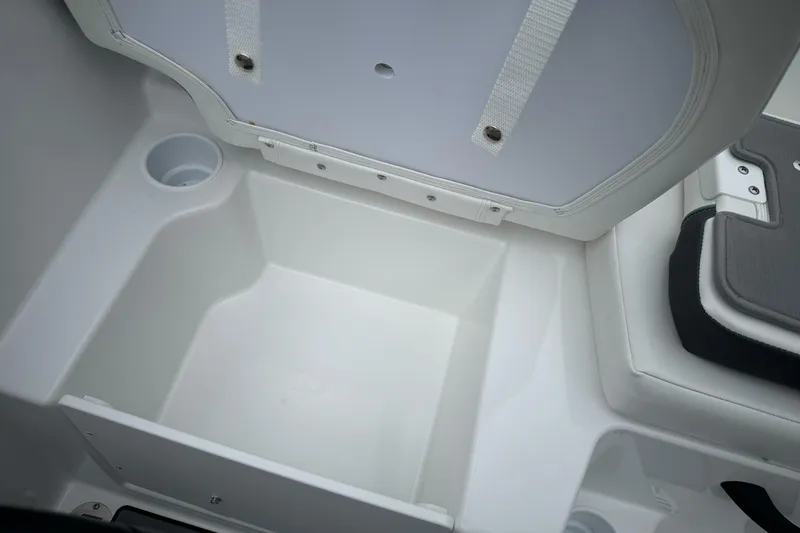 Slide: The Image of 2026 Tahoe T18 boat storage compartment with cup holder, open lid view. - 7
