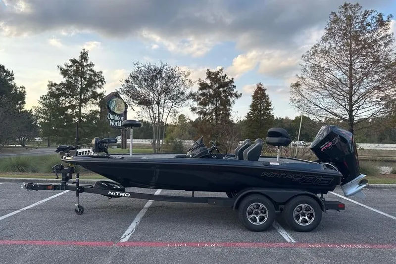 The Image of 2026 Nitro Z19 XL boat parked outdoors near trees and a sign. - 0