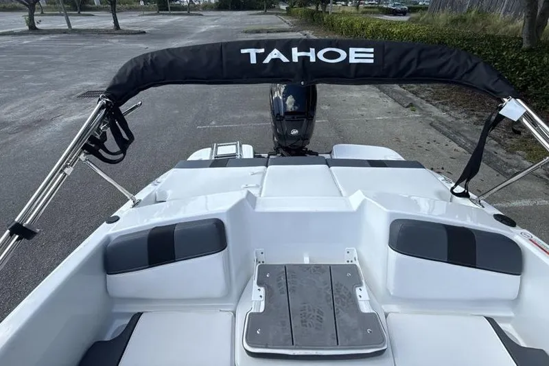 Slide: The Image of 2026 Tahoe T16 boat with black canopy and seating, parked on pavement. - 5