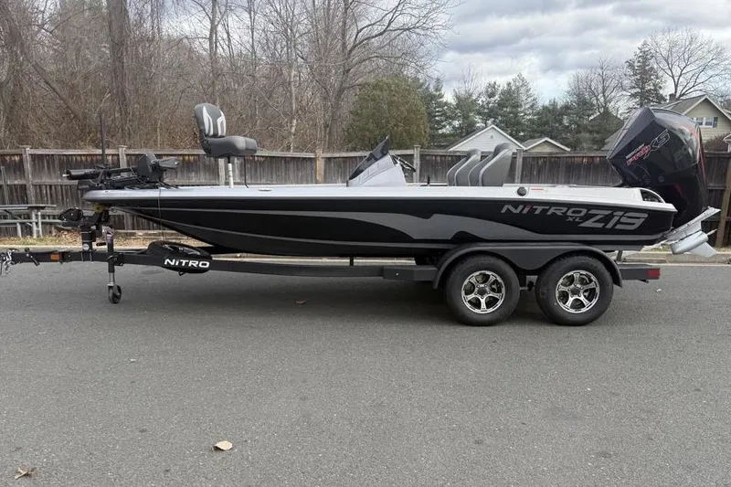 The Image of 2026 Nitro Z19 XL Pro boat on trailer, parked on road, with trees in background. - 0