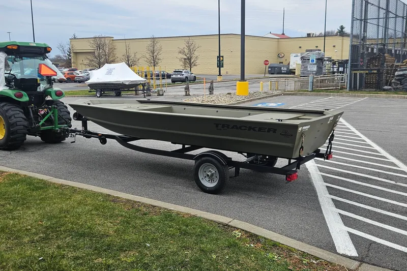 Slide: The Image of 2026 Tracker Grizzly 1648 Utility boat on trailer, parked in a lot. - 2