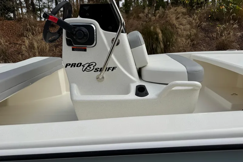 Slide: The Image of 2026 Mako Pro Skiff 13 CC boat console with steering wheel and seating. - 2