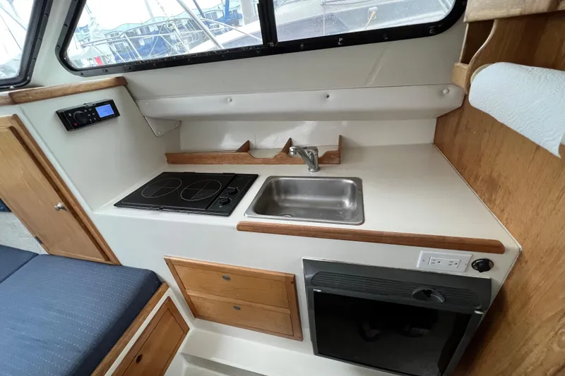 Slide: The Image of Compact galley in 2001 Skipjack 262 Flybridge with stove, sink, and storage. - 12
