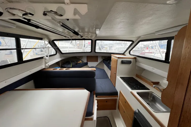 Slide: The Image of Interior of 2001 Skipjack 262 Flybridge boat with kitchenette and seating area. - 7