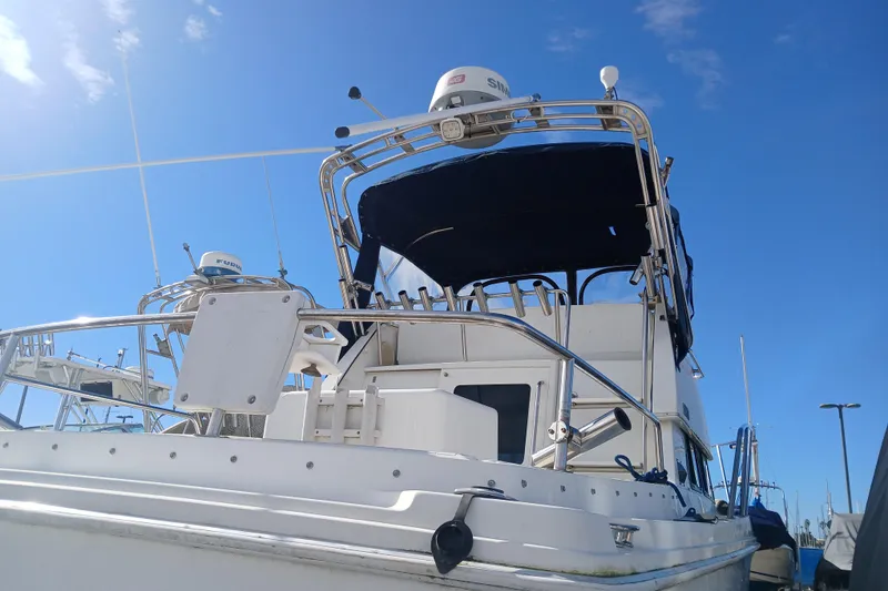 Slide: The Image of 2001 Skipjack 262 Flybridge boat under clear blue sky, showcasing upper deck and equipment. - 9