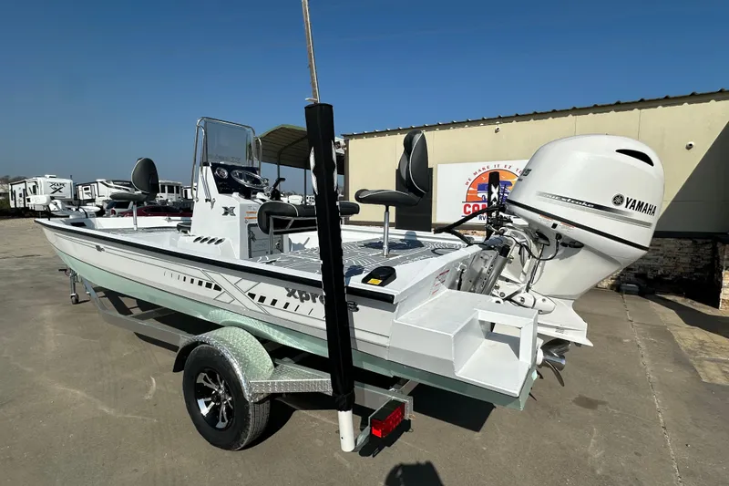 Slide: The Image of 2026 Xpress SW20B boat with Yamaha motor on trailer, parked outdoors. - 5