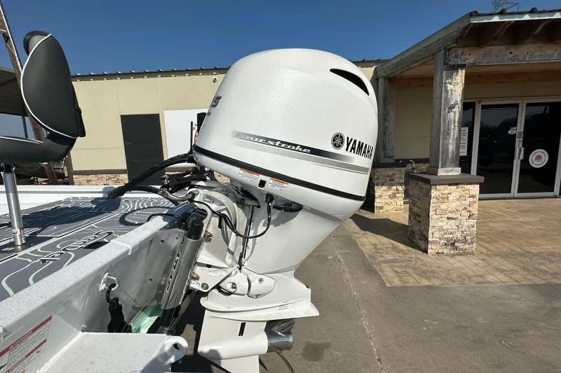 Slide: The Image of 2026 Xpress SW20B boat with Yamaha outboard motor, parked outside a building. - 6