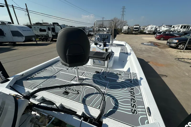 Slide: The Image of 2026 Xpress SW20B boat with modern design, parked near RVs and vehicles. - 8