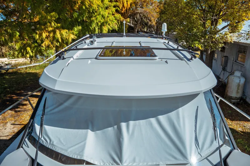 Slide: The Image of 2024 Jeanneau NC 795 Series 2 boat, top view with sunroof, surrounded by trees. - 24