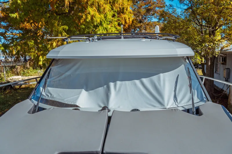 Slide: The Image of 2024 Jeanneau NC 795 Series 2 boat with covered windshield, surrounded by trees. - 25