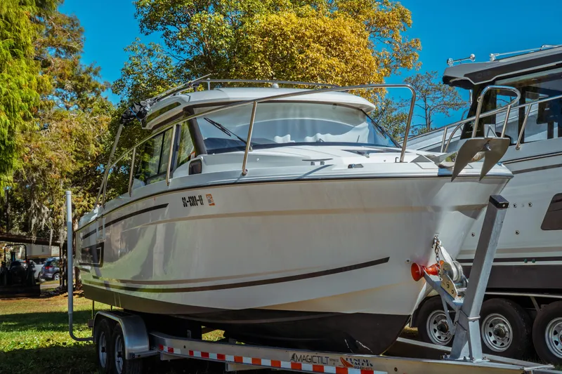 Slide: The Image of 2024 Jeanneau NC 795 Series 2 boat on trailer, surrounded by trees. - 3