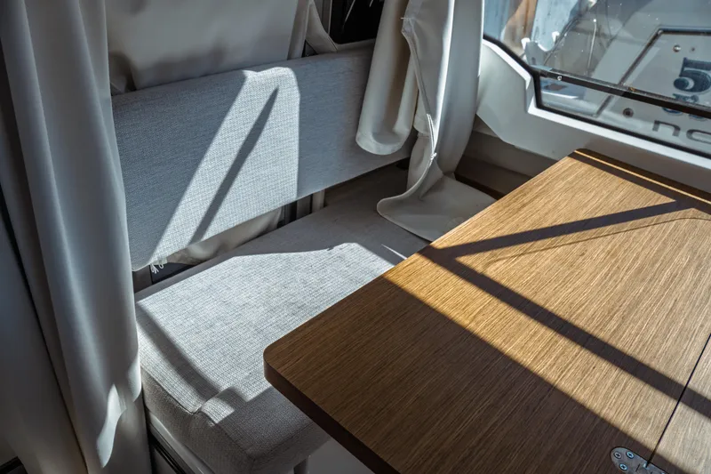 Slide: The Image of Interior of 2024 Jeanneau NC 795 Series 2, featuring a wooden table and cushioned seating. - 32