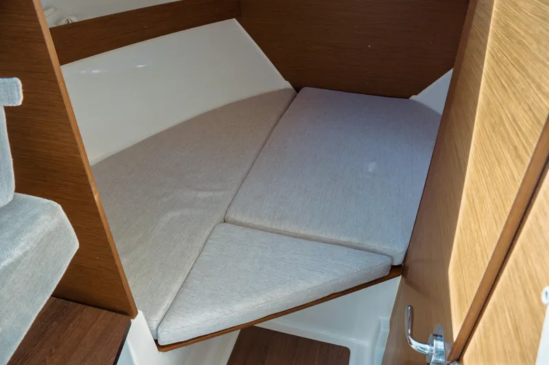 Slide: The Image of 2024 Jeanneau NC 795 Series 2 cabin interior with cozy bed and wooden accents. - 41