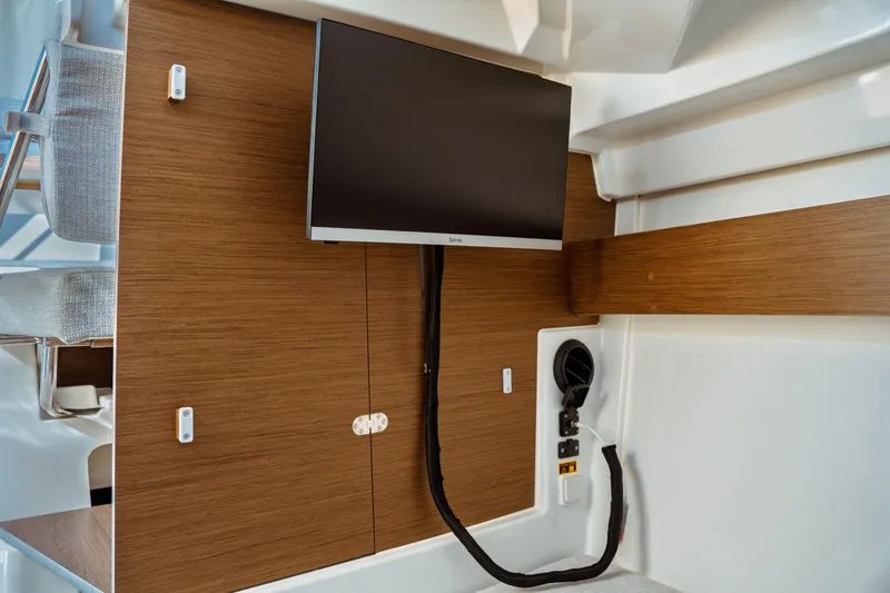 Slide: The Image of 2024 Jeanneau NC 795 Series 2 interior with mounted TV and wooden paneling. - 43