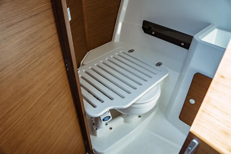 Slide: The Image of 2024 Jeanneau NC 795 Series 2 boat bathroom with compact toilet and wooden accents. - 45