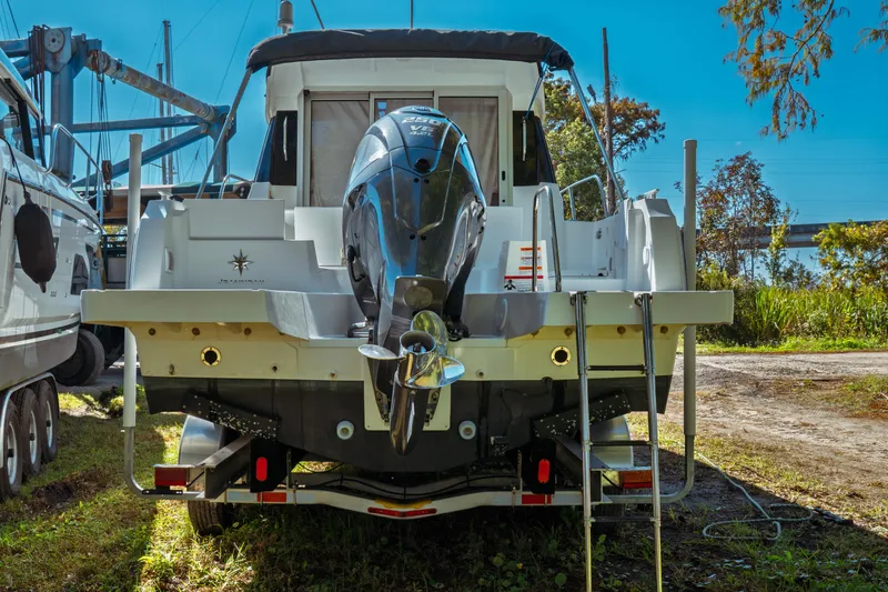 Slide: The Image of 2024 Jeanneau NC 795 Series 2 boat with outboard motor, docked outdoors. - 6