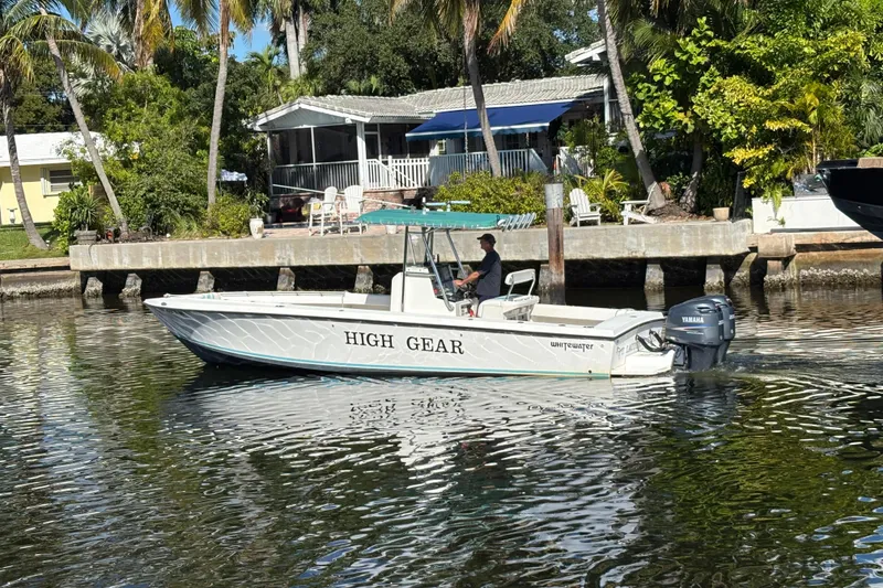 Slide: The Image of Whitewater 28 boat named "High Gear" cruising on a sunny waterfront. - 1