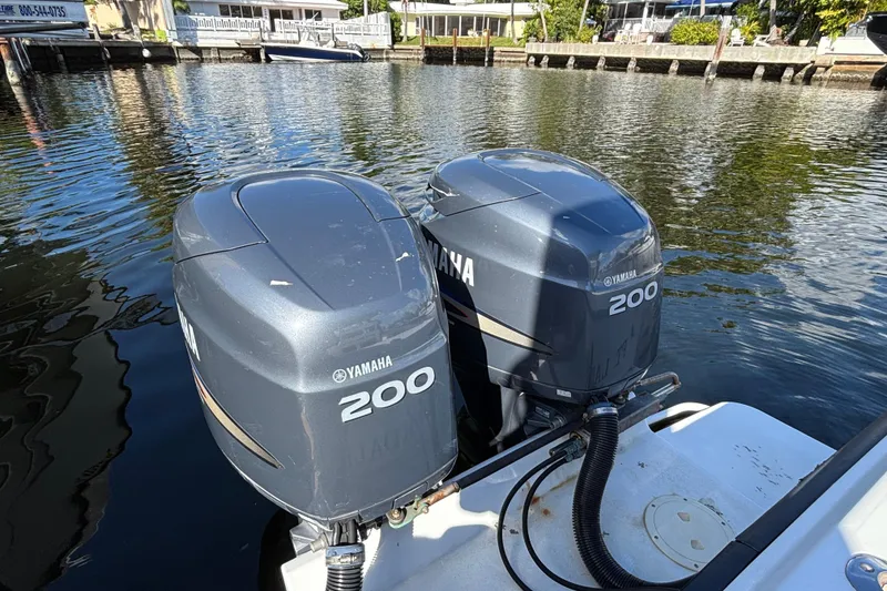 Slide: The Image of Twin Yamaha 200 outboard motors on a 1995 Whitewater 28 boat, docked by the water. - 14