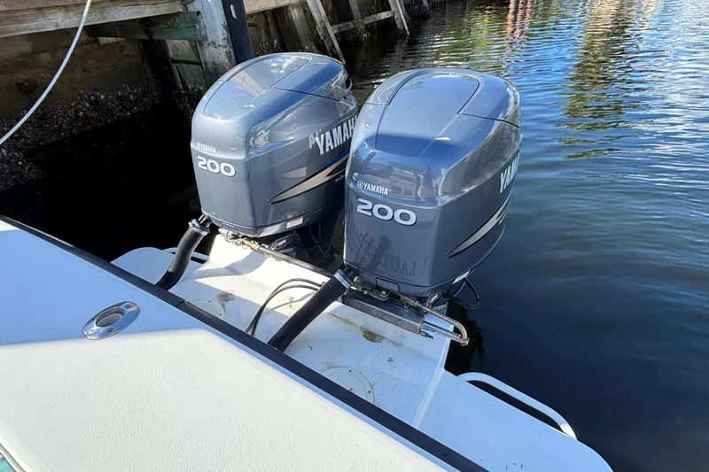 Slide: The Image of Twin Yamaha 200 outboard engines on a 1995 Whitewater 28 boat, docked by wooden pier. - 15