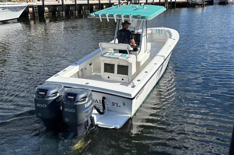 Slide: The Image of 1995 Whitewater 28 boat with dual Yamaha 200 engines on a calm waterway. - 4