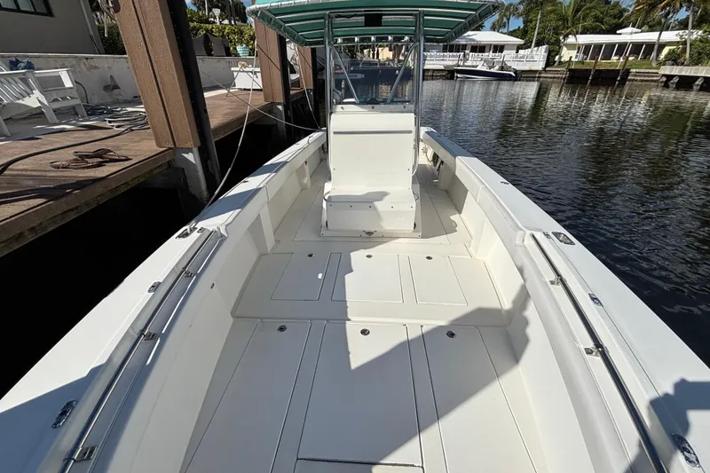 Slide: The Image of 1995 Whitewater 28 boat docked, featuring spacious deck and canopy. - 7