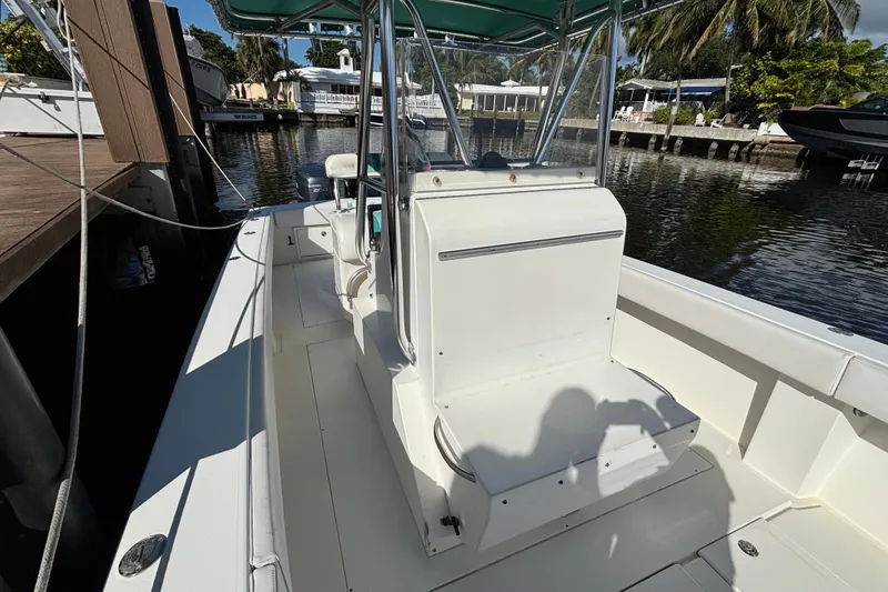 Slide: The Image of 1995 Whitewater 28 boat interior at dock, featuring seating and canopy. - 8
