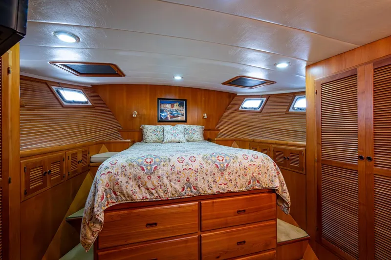 Slide: The Image of Luxurious 2006 Krogen 58 yacht bedroom with wood paneling and cozy bedding. - 33