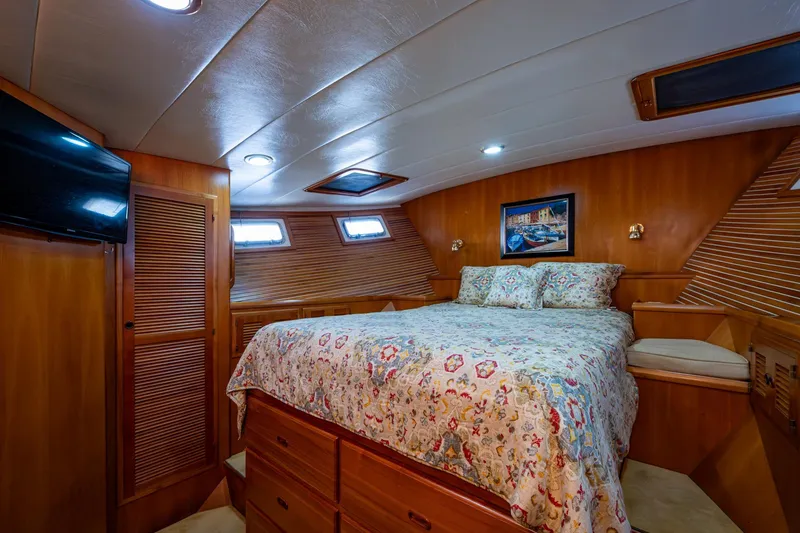 Slide: The Image of Luxurious 2006 Krogen 58 yacht bedroom with cozy bed and elegant wood paneling. - 34
