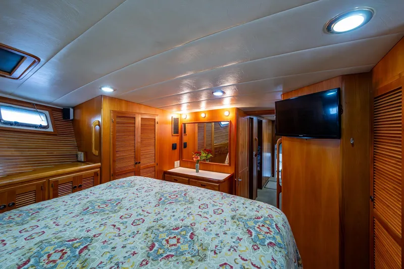 Slide: The Image of Luxurious cabin interior of 2006 Krogen 58 yacht with wood paneling and floral bedding. - 36