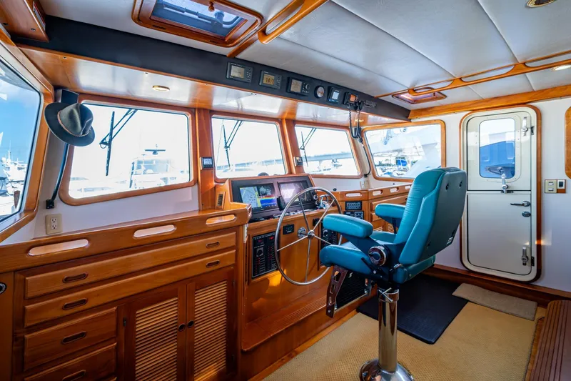 Slide: The Image of 2006 Krogen 58 yacht helm with wooden interior and blue captain's chair. - 43