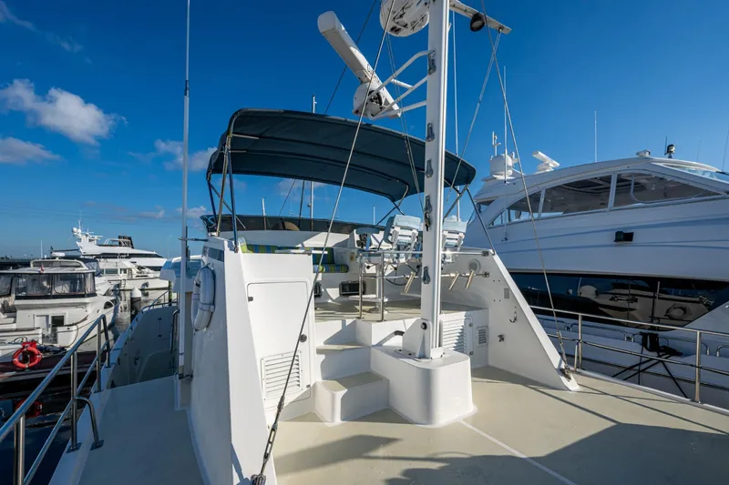 Slide: The Image of 2006 Krogen 58 yacht deck with blue canopy, docked among other boats. - 50