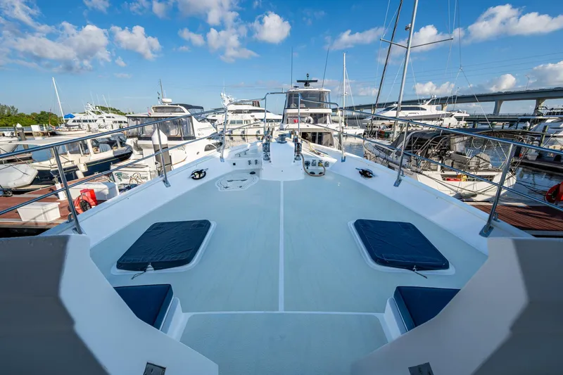 Slide: The Image of 2006 Krogen 58 yacht deck view at marina, surrounded by boats under blue sky. - 52