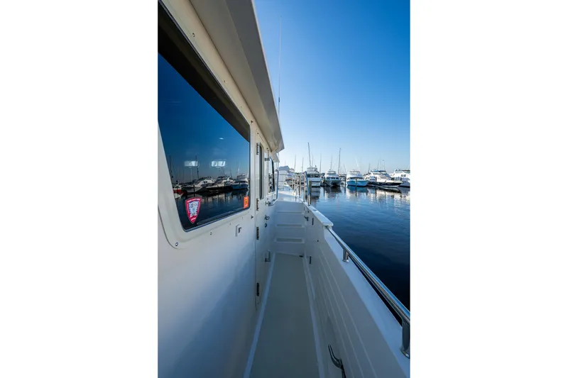 Slide: The Image of Side view of 2006 Krogen 58 yacht docked at marina under clear blue sky. - 56