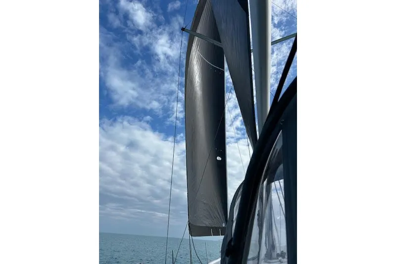 Slide: The Image of Sailing on a 2016 Jeanneau 54 yacht with sails unfurled under a partly cloudy sky. - 12