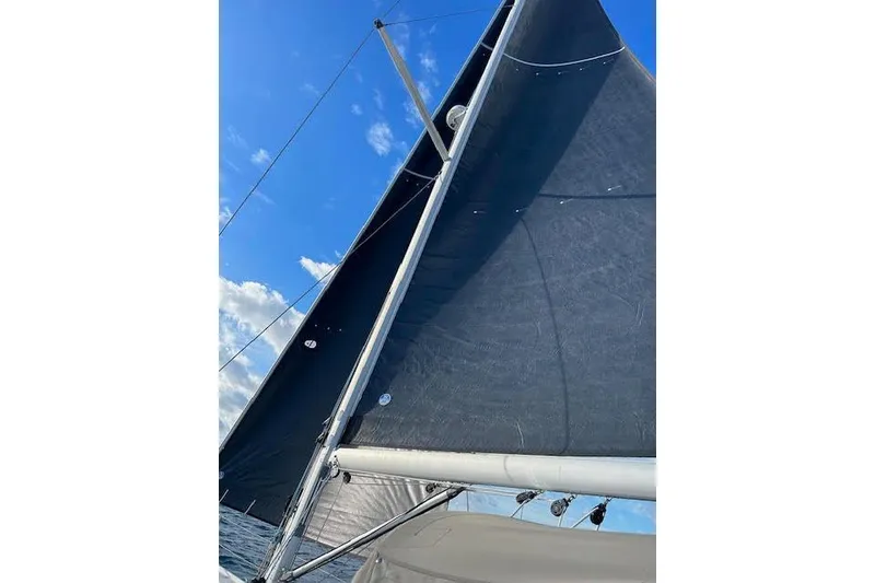 Slide: The Image of Sailing yacht Jeanneau 54, 2016 model, with sails unfurled against a clear blue sky. - 13