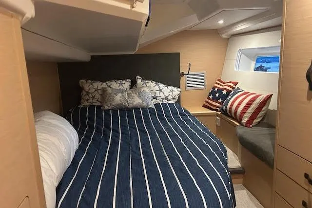 Slide: The Image of Cozy cabin interior of 2016 Jeanneau 54 yacht with striped bedding and decorative pillows. - 18