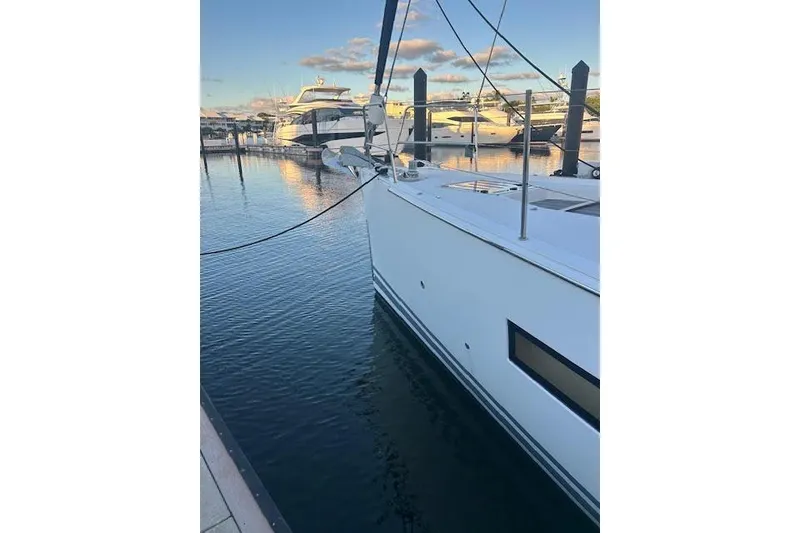 Slide: The Image of 2016 Jeanneau 54 yacht docked in a serene marina setting. - 29