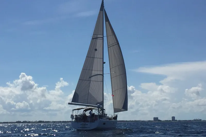 Slide: The Image of 2016 Jeanneau 54 yacht sailing on a clear blue sea under a bright sky. - 3