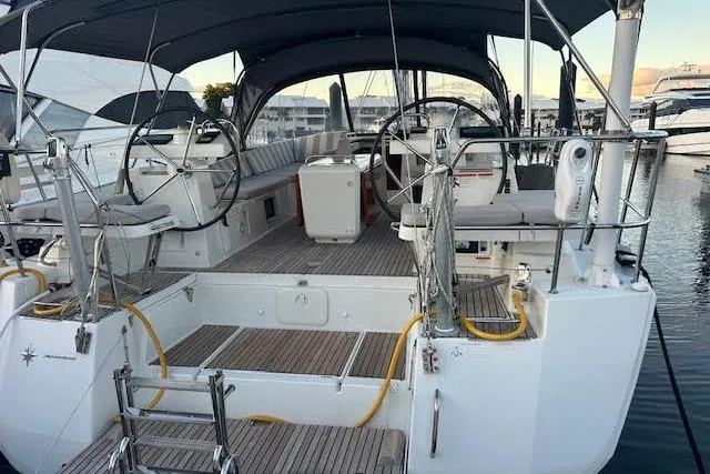 Slide: The Image of 2016 Jeanneau 54 sailboat with dual steering wheels, docked at a marina. - 36