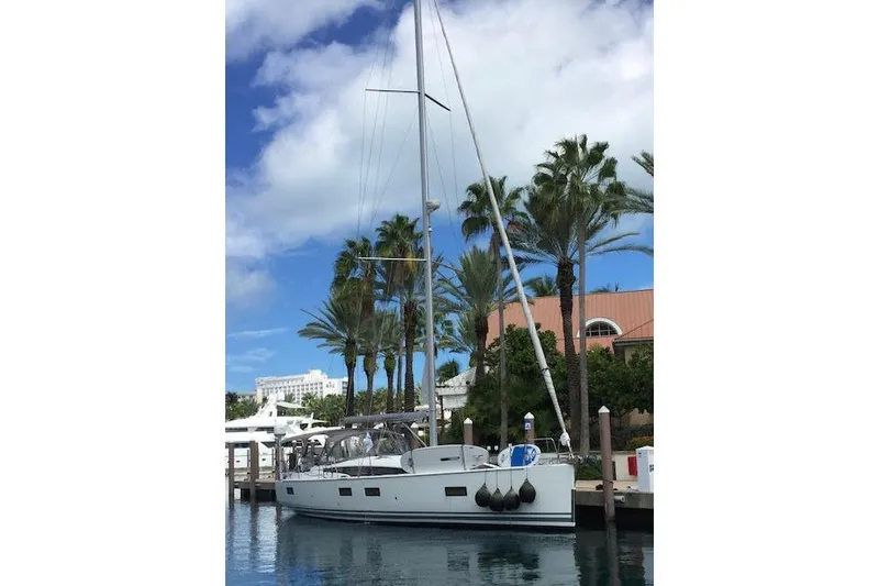 Slide: The Image of 2016 Jeanneau 54 sailboat docked by palm trees under a blue sky. - 5