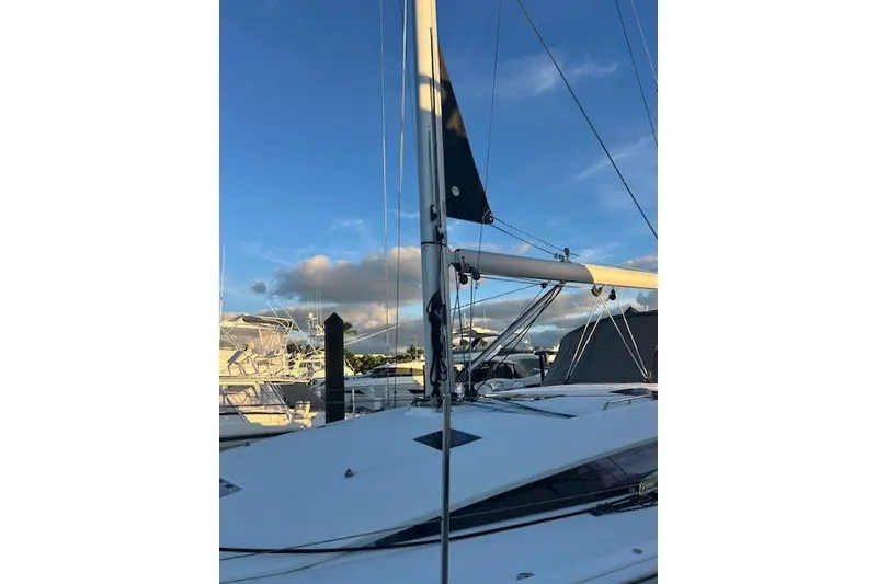 Slide: The Image of 2016 Jeanneau 54 sailboat mast against a clear blue sky at marina. - 7