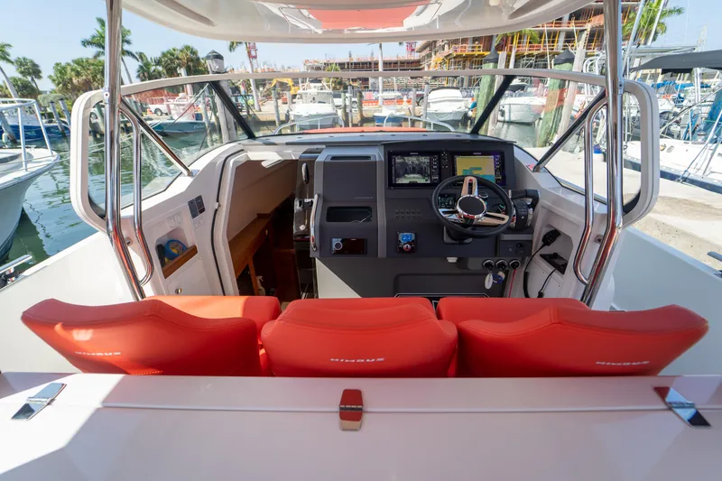 Slide: The Image of Interior of a 2022 Nimbus T11 boat with red seating and helm console. - 4