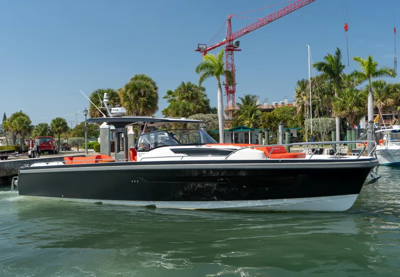 The Image of Nimbus T11 2022 motorboat docked at harbor with palm trees. - 0