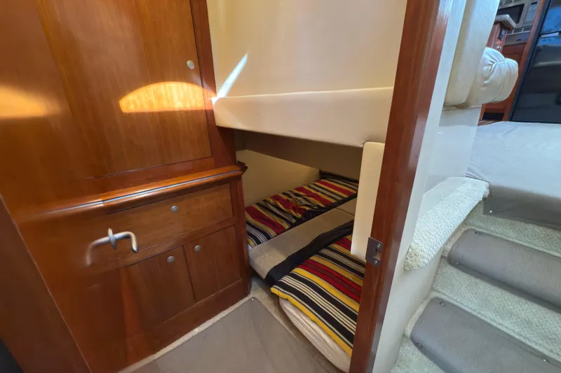 Slide: The Image of Interior of 2008 Cruisers 455 Motor Yacht with cozy bunk beds and wooden cabinetry. - 25