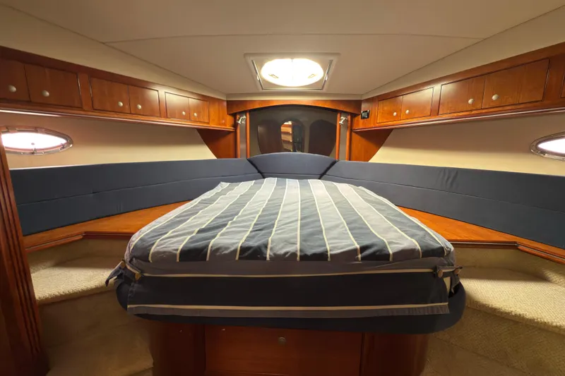 Slide: The Image of Luxurious 2008 Cruisers 455 Motor Yacht bedroom with elegant wood cabinetry and cozy bedding. - 21