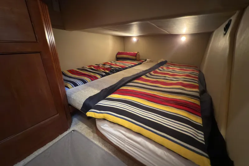 Slide: The Image of Interior of 2008 Cruisers 455 Motor Yacht with twin beds and striped bedding. - 26