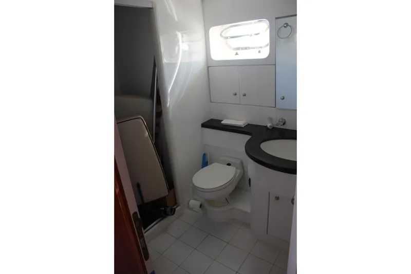 Slide: The Image of Bathroom interior of 1999 Horizon 70 Motor Yacht, featuring modern fixtures and cabinetry. - 13