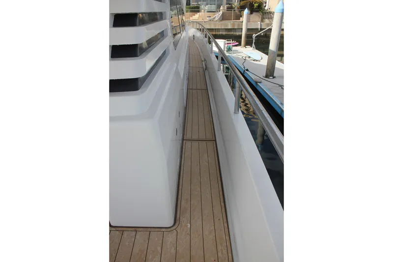 Slide: The Image of Side deck of a 1999 Horizon 70 Motor Yacht with wooden flooring and railing. - 30